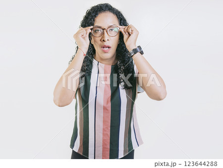 Latin girl taking off her glasses looking a promotion. Surprised woman taking off glasses isolated. Amazed afro girl taking off glasses by a promotion 123644288