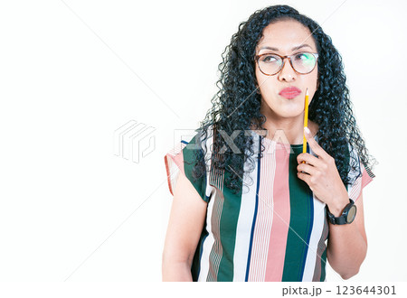 Thoughtful young woman in glasses holding a pencil. Afro girl thinking holding pencil on chin Thoughtful young woman in glasses holding a pencil. Afro girl thinking holding pencil on chin 123644301