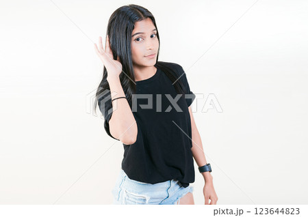 Young girl with hand on ear hearing a rumor isolated. Beautiful teenage girl listening to a rumor isolated 123644823