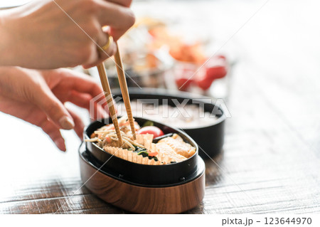 キッチンでお弁当を詰める女性の手元（愛妻弁当） 123644970
