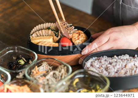 キッチンでお弁当を詰める女性の手元（愛妻弁当） 123644971