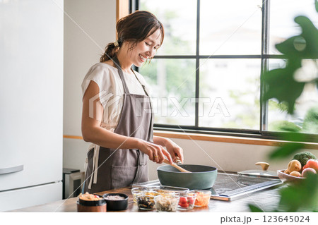 キッチンで料理をする若いアジア人女性（クッキング・手料理） 123645024