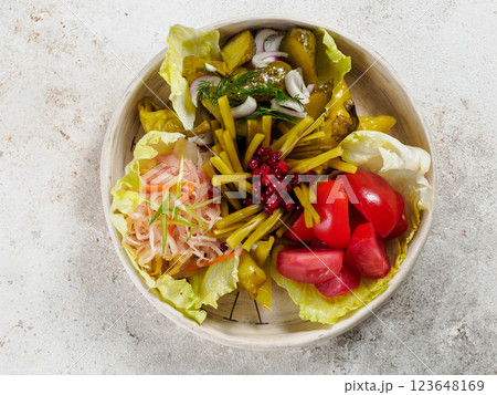 Assorted snacks from fermented cabbage, cucumbers and tomatoes, green bean. Decorated cranberry. Fermented healthy food concept. Pickled cucumbers, marinated tomatoes, Top view or flat lay. Assorted snacks from fermented cabbage, cucumbers and tomatoes, green bean. Decorated cranberry. Fermented healthy food concept. Pickled cucumbers, marinated tomatoes, Top view or flat lay. 123648169