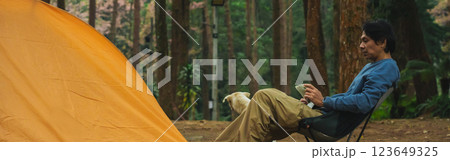 solo traveler in nature concept with asian man camping and work online with pink cherry blossom and pine tree in springtime season solo traveler in nature concept with asian man camping and work online with pink cherry blossom and pine tree in springtime season 123649325