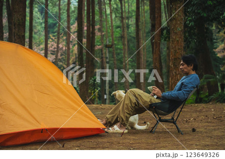 solo traveler in nature concept with asian man camping and work online with pink cherry blossom and pine tree in springtime season solo traveler in nature concept with asian man camping and work online with pink cherry blossom and pine tree in springtime season 123649326