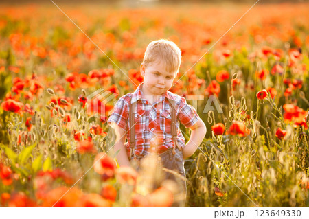 A little boy with strabismus plays in the field, exploring the plants 123649330