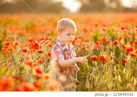 A small boy with an eye condition enjoys exploring the plants while playing in the field 123649332