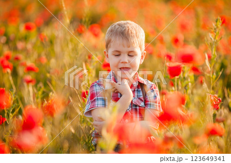 A little boy with strabismus plays in the field, exploring the plants 123649341
