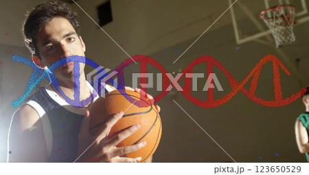 Holding basketball, athlete with DNA strand image over background Holding basketball, athlete with DNA strand image over background 123650529