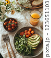 Fresh avocado toast with cherry tomatoes and arugula, served with orange juice. vibrant and healthy breakfast option, perfect for sunny morning 123651103