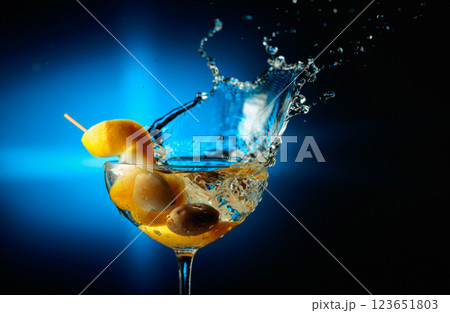 Lemon wedge falls into a martini glass. Lemon wedge falls into a martini glass. 123651803
