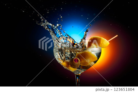 Lemon wedge falls into a martini glass. 123651804