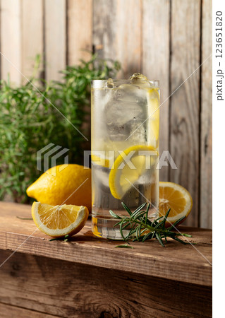 Summer refreshing drink with ice, rosemary and lemon slices on a old wooden table. 123651820