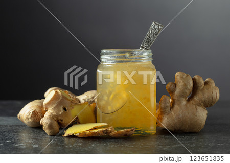Ginger jam in jar and fresh ginger on a black background. Ginger jam in jar and fresh ginger on a black background. 123651835