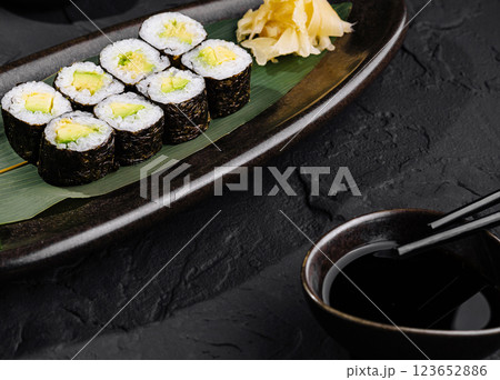 Avocado sushi roll with soy sauce on slate background Avocado sushi roll with soy sauce on slate background 123652886