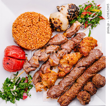 Delicious grilled meats and rice served on a white platter Delicious grilled meats and rice served on a white platter 123652945