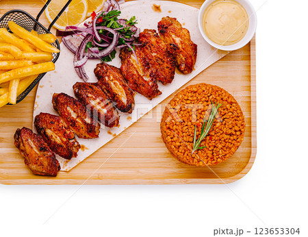 Savory grilled chicken wings served with rice and fries 123653304