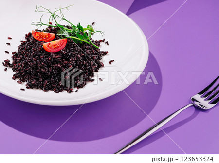 Delicious black rice dish garnished with fresh tomatoes and herbs Delicious black rice dish garnished with fresh tomatoes and herbs 123653324