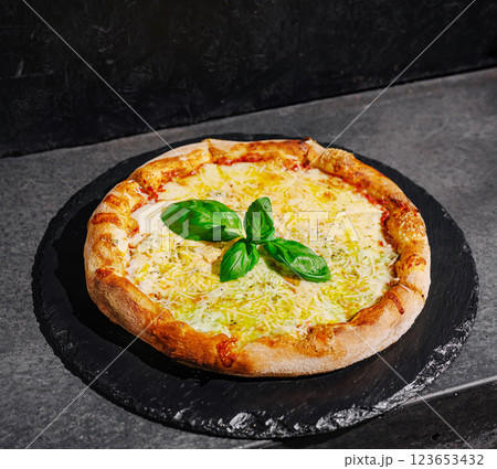 Deliciously baked cheese pizza featuring fresh basil leaves 123653432