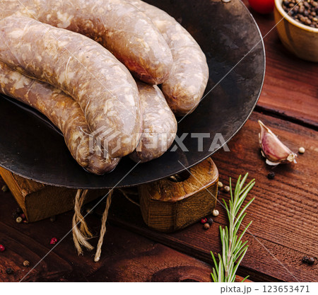 Juicy sausages on cast iron skillet with fresh herbs and spices 123653471