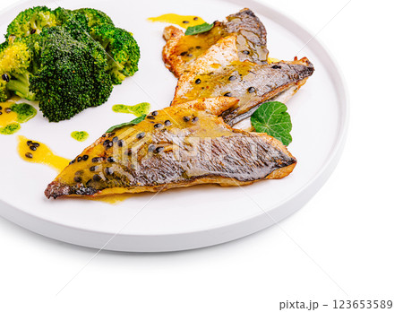 Freshly cooked fish with broccoli and sauce on a white plate Freshly cooked fish with broccoli and sauce on a white plate 123653589