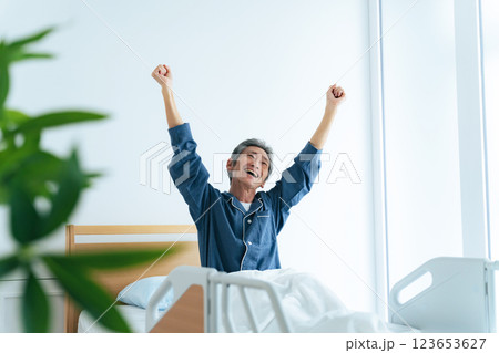 ベッドで爽快に目覚めるシニア男性 ベッドで爽快に目覚めるシニア男性 123653627