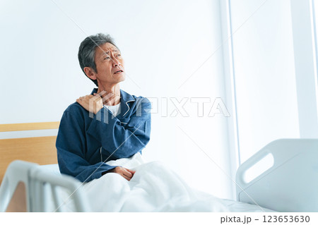 ベッドで起き上がって疲れに悩むシニア男性 123653630