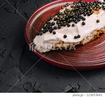 Delicious dessert topping with black pearls on a pastry plate 123653641