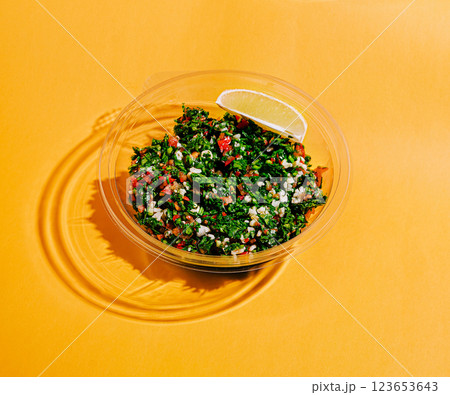 Fresh tabbouleh salad with lemon slice on vibrant background Fresh tabbouleh salad with lemon slice on vibrant background 123653643