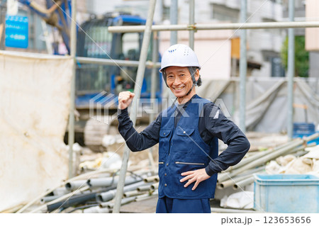 工事現場の前に笑顔で立つ職人 工事現場の前に笑顔で立つ職人 123653656