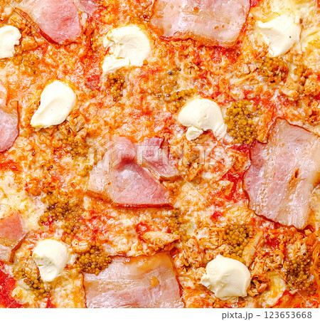 Delicious pizza topped with cheese, ham, and mustard spread Delicious pizza topped with cheese, ham, and mustard spread 123653668