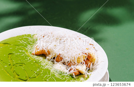 Delicious green soup topped with cheese on a plate 123653674