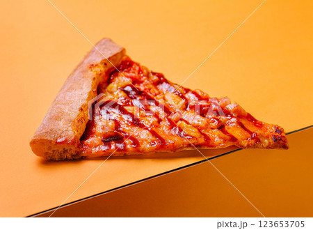 Delicious slice of pizza with barbecue sauce on vibrant background Delicious slice of pizza with barbecue sauce on vibrant background 123653705