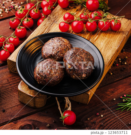 Savory meatballs served on a wooden board with fresh tomatoes Savory meatballs served on a wooden board with fresh tomatoes 123653711
