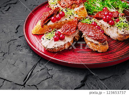 Delicious bruschetta topped with sun-dried tomatoes and sprouts Delicious bruschetta topped with sun-dried tomatoes and sprouts 123653737