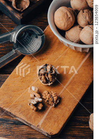 Cracked walnuts on cutting board Cracked walnuts on cutting board 123654009