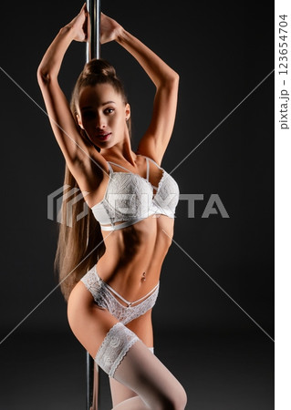 Woman performing an elegant dance around a pole in stylish lingerie indoors Woman performing an elegant dance around a pole in stylish lingerie indoors 123654704