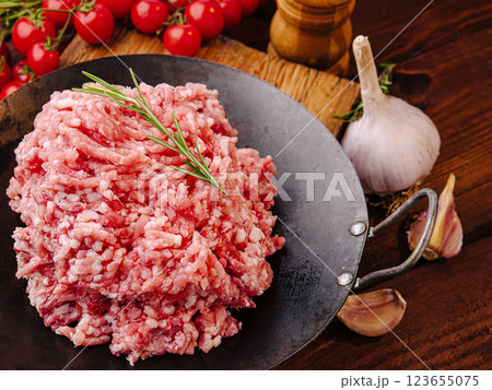 Freshly minced meat on a rustic kitchen counter with herbs 123655075