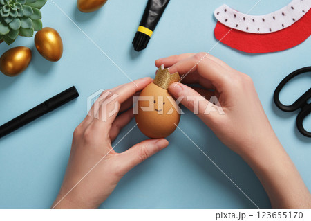 DIY Easter Egg King. Step-by-step instructions. Step 9: Attach the crown to the eggshell with glue. 123655170
