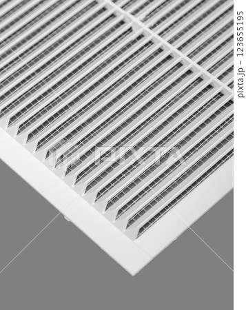 White ventilation grate on a gray background. Close-up. Material is plastic. 123655195