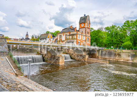 The stunning Art Nouveau building of the Hucak hydropower station graces the banks of the river in Hradec Kralove, showcasing intricate design and vibrant nature in the surrounding landscape. 123655977