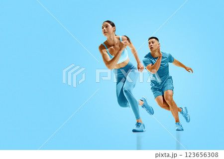 Energetic collage. Duo of athletes, man and woman, dressed in blue sprinting forward, strength and focus blending into action. Energetic collage. Duo of athletes, man and woman, dressed in blue sprinting forward, strength and focus blending into action. 123656308