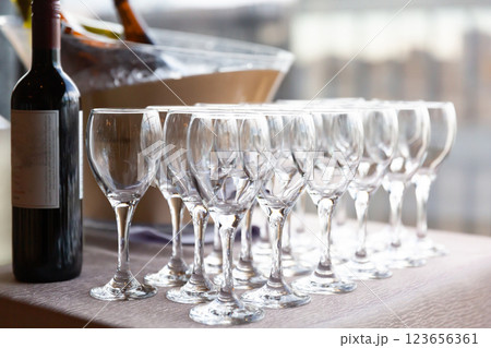 パーティー会場内のドリンクテーブルに並ぶワイングラスとボトル 123656361