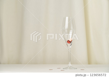 Wine glass with heart confetti on cream background Wine glass with heart confetti on cream background 123656572