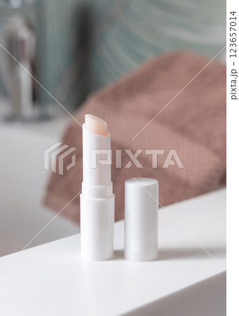 Opened white blank lip balm stick on basin in tropical bathroom close up, cosmetic mockup Opened white blank lip balm stick on basin in tropical bathroom close up, cosmetic mockup 123657014