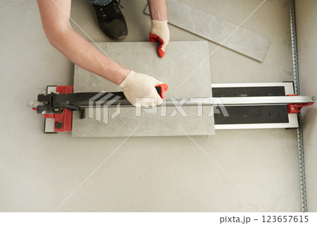The master machine cuts the tile into two parts. A machine for cutting large ceramic tiles into smaller tiles with precise dimensions. High quality photo 123657615