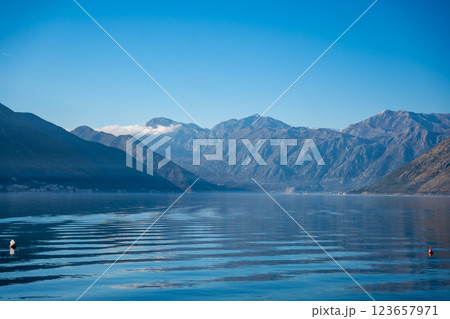 Bay of Kotor in Montenegro and the top of high snow-capped mountains, small settlements on the coast and the bright blue waters of the Adriatic Sea. 123657971