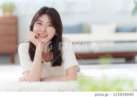 床に寝転ぶ笑顔の女性 123658040