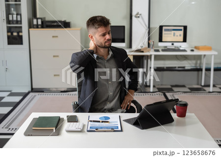 Male businessman is doing a stretchy posture due to sitting in the office for too long. Male businessman is doing a stretchy posture due to sitting in the office for too long. 123658676