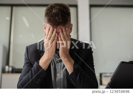 Businessman male stressed over credit card debt monthly expenses in office. 123658696